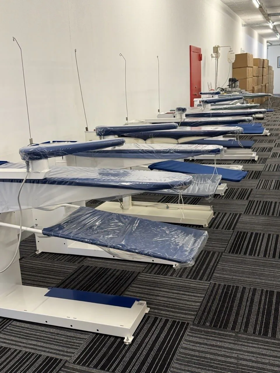 A row of vacuum ironing tables in the Universe Corp showroom